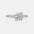 A silver-toned diamond ring with a floral cluster setting featuring marquise and round-cut clear stones, shown on a light gray background.