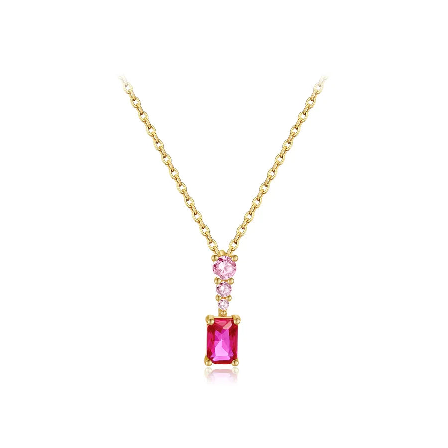A yellow gold necklace featuring a rectangular emerald-cut pink gemstone pendant, accented by a smaller round pink gemstone and tiny clear stones on the chain, set against a solid white background.