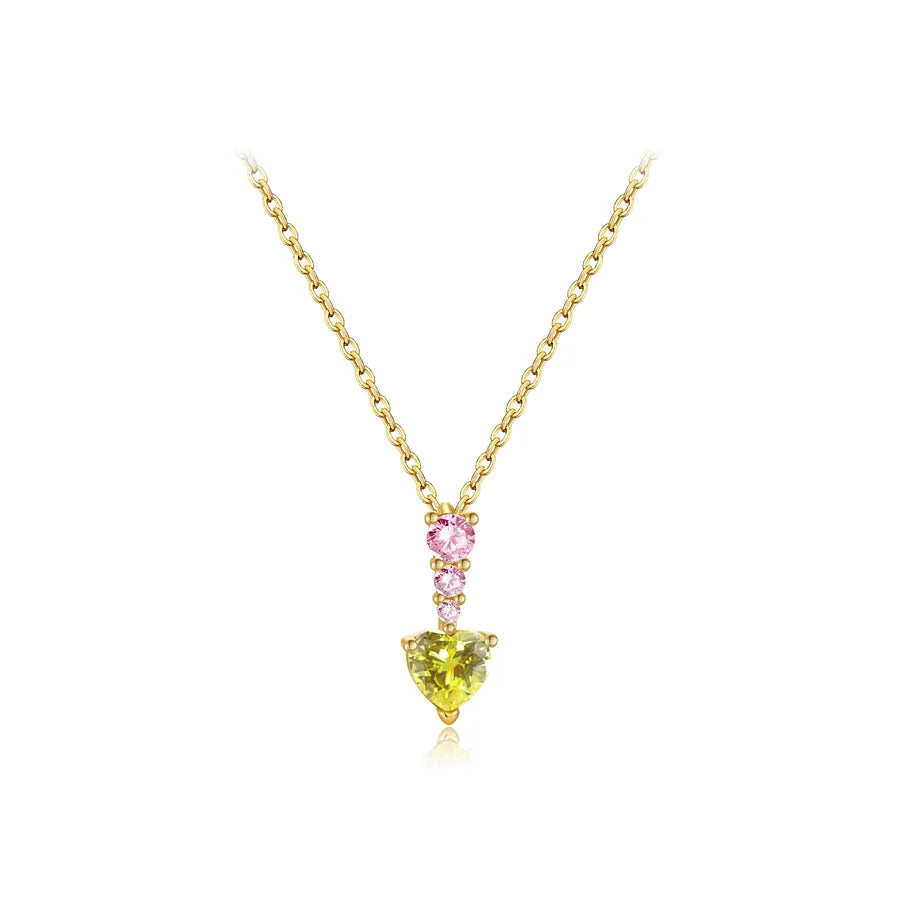 A yellow gold necklace with a heart-shaped pendant featuring a green peridot gemstone and a smaller pink heart gemstone, set against a plain white background.