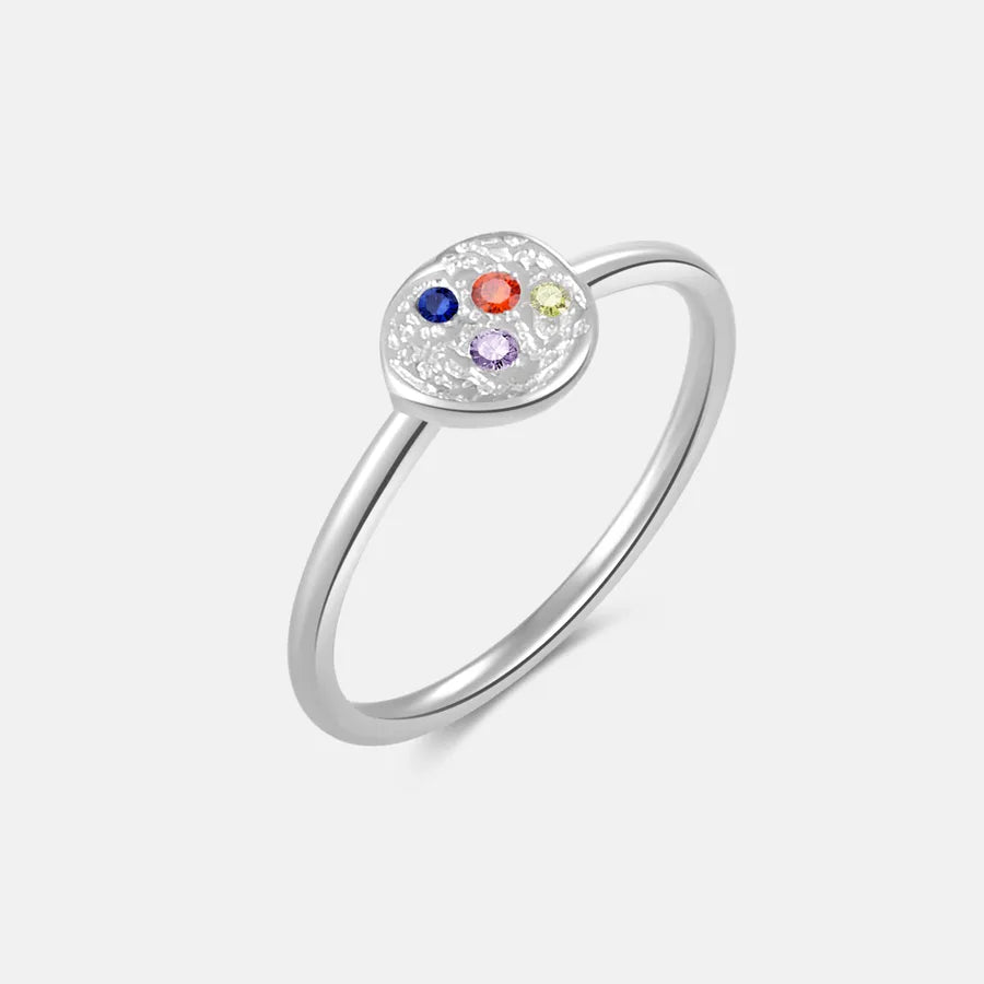 Silver ring with colorful gemstones on a light gray background