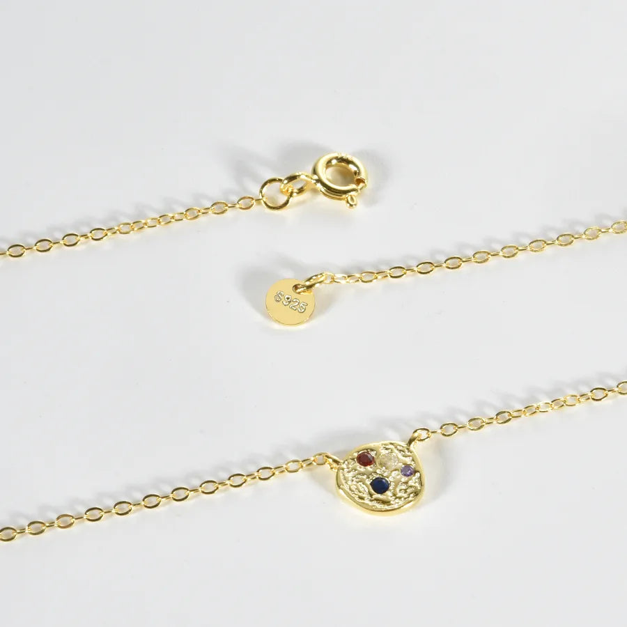 Gold chain necklace with a small oval charm featuring a red heart, blue heart, and white heart design, shown alongside a lobster clasp and a 925 sterling silver hallmark disc on a white background.