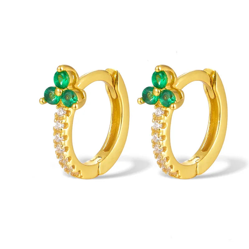 Gold hoop earrings with green gemstones on a white background
