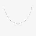 A delicate silver chain necklace with small, evenly spaced round bezel-set clear stones, displayed on a clean white background with a faint reflection below.