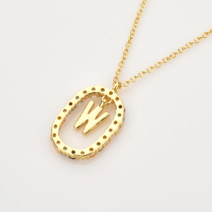 Gold necklace with a circular pendant featuring a letter 'W'.