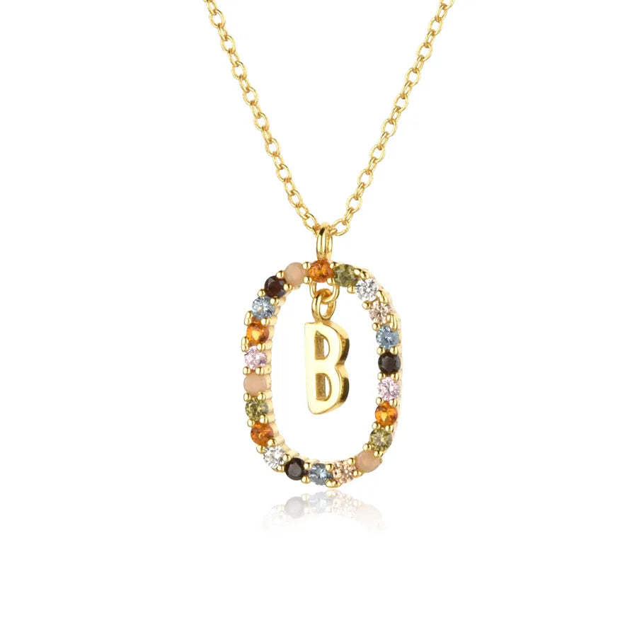 Gold necklace with a pendant featuring the letter 'B' on a white background