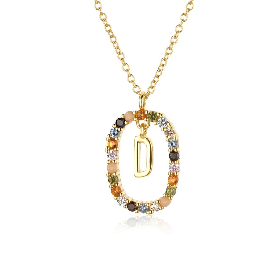 Gold necklace with a pendant featuring the letter 'D' and multicolored stones on a white background