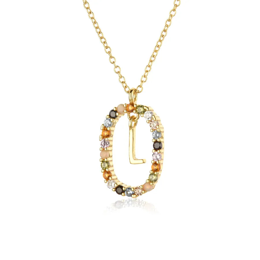 Gold necklace with a multicolored gemstone pendant on a white background