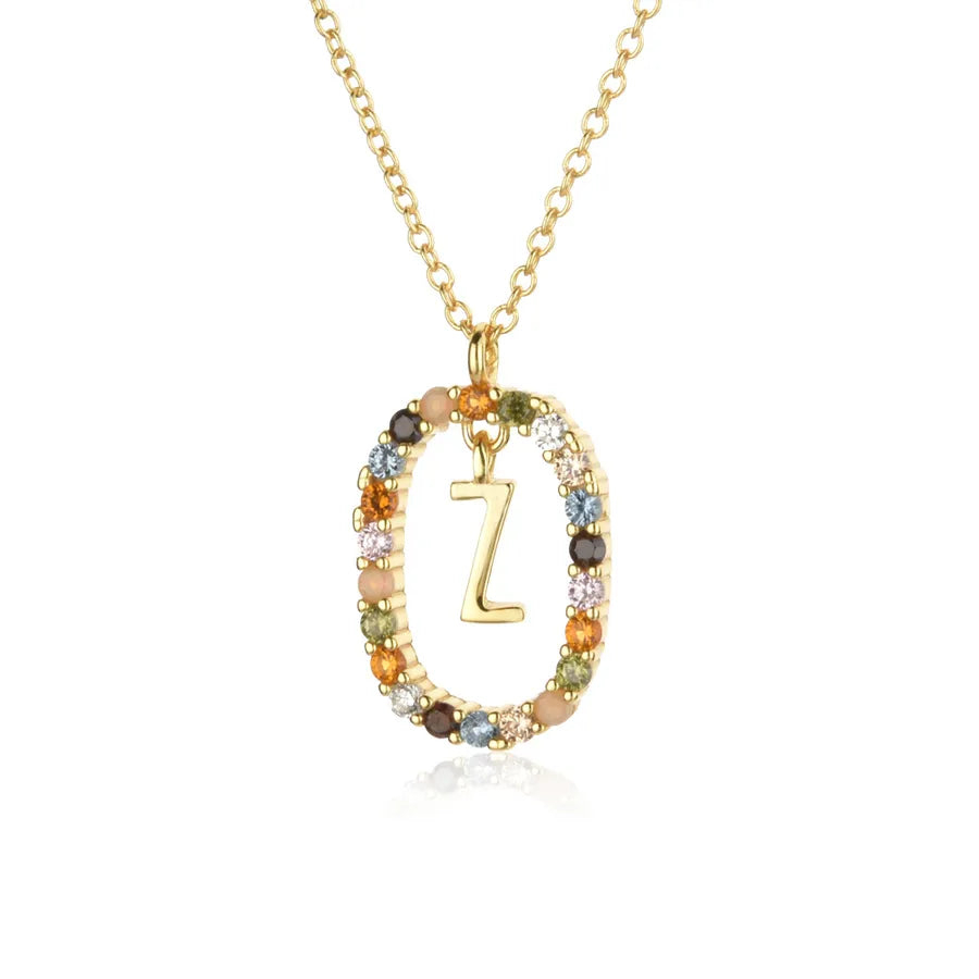 Gold necklace with a 'Z' pendant and multicolored stones on a white background