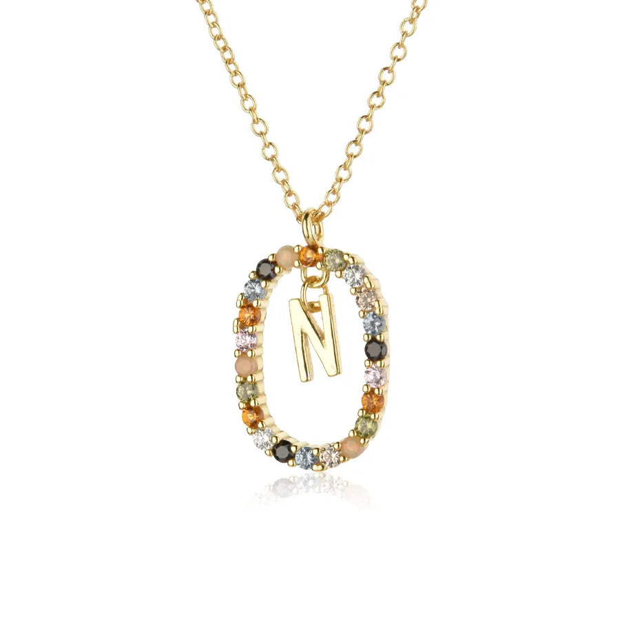 Gold necklace with a pendant featuring the letter 'N' on a white background