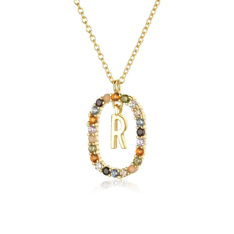 Gold necklace with a 'R' pendant and multicolored stones on a white background