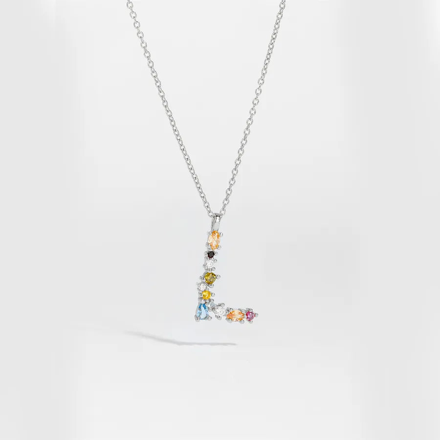 A silver-tone chain necklace with a pendant shaped like the letter 'L', adorned with multiple small colorful gemstones in yellow, blue, pink, orange, and black, set against a clean white background.