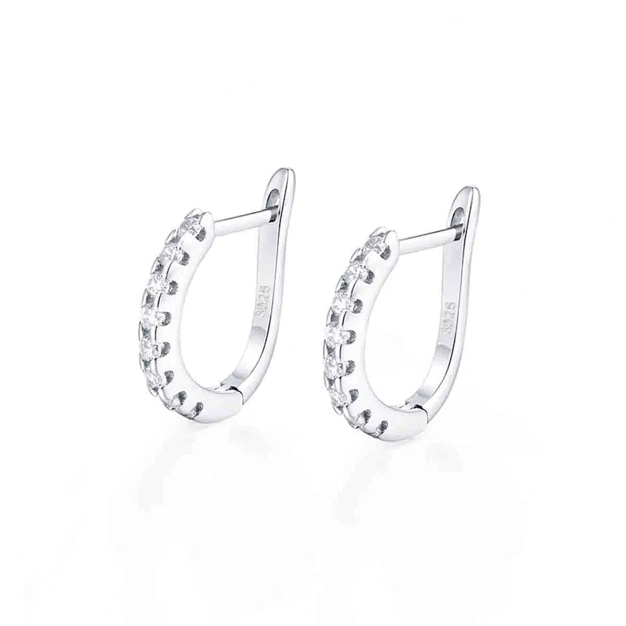 A pair of silver huggie hoop earrings with small clear stones set along the front, displayed on a clean white background.