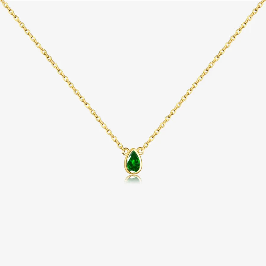 Gold necklace with a green teardrop pendant on a white background
