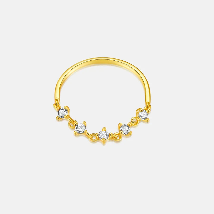 Gold ring with small diamonds on a light gray background