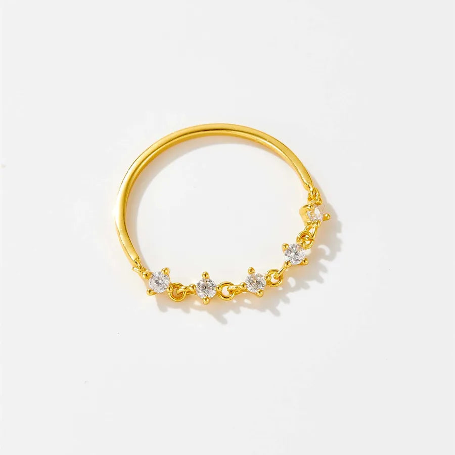 Gold ring with small diamonds on a light gray background