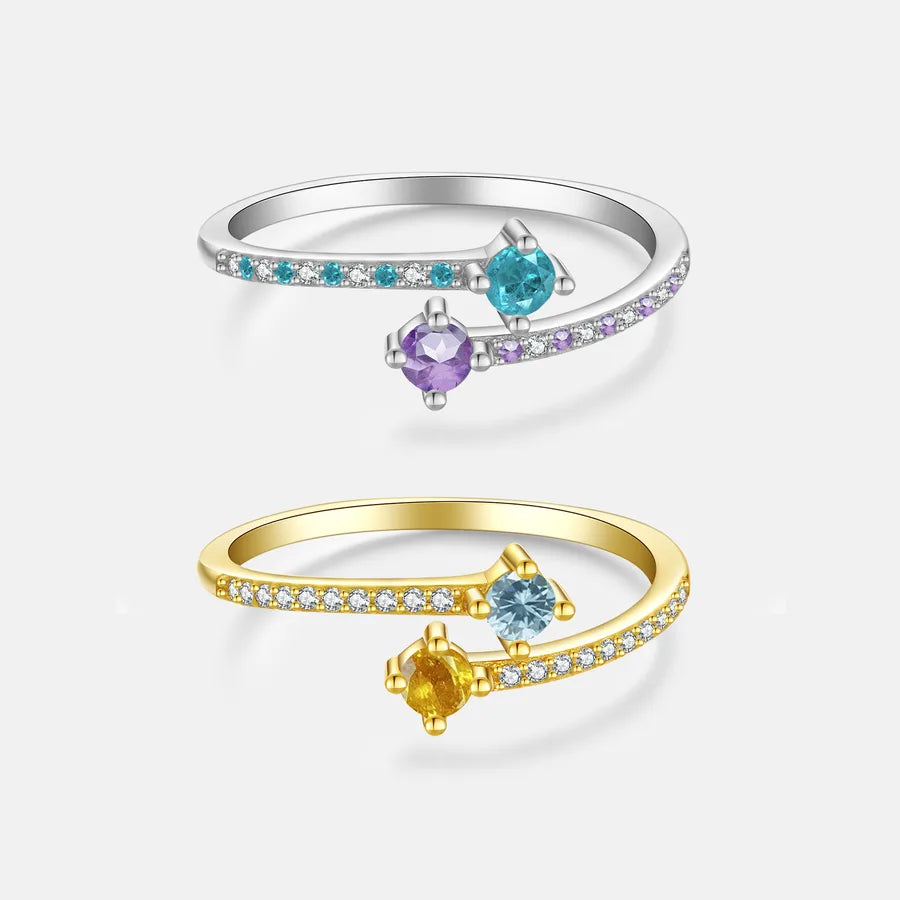 Two rings, one gold and one silver, with colorful gemstones on a white background